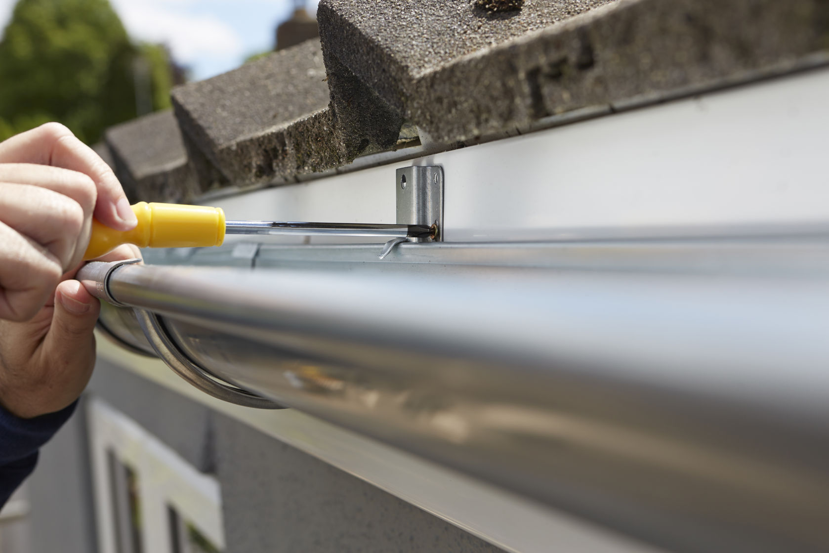 roofer tightening crew of new gutter